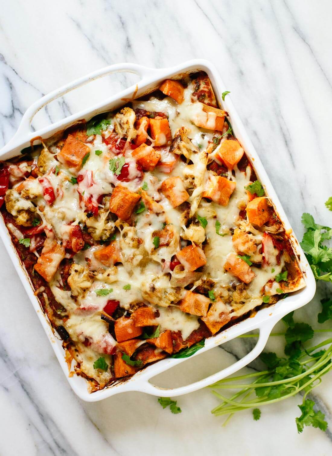 Delicious enchilada casserole stuffed with roasted veggies, black beans, salsa and spinach! This is a hearty and redeeming dinner recipe. cookieandkate.com